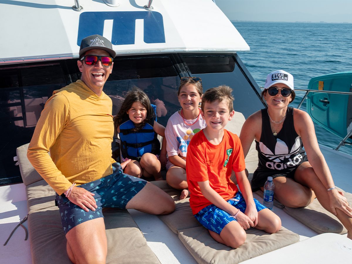 Family smiling on a sportfishing boat tour in Puerto Vallarta without seasickness.