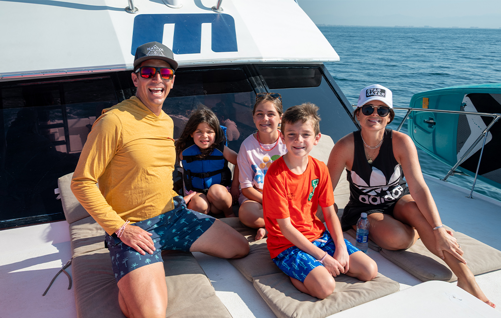 Family smiling on a sportfishing boat tour in Puerto Vallarta without seasickness.